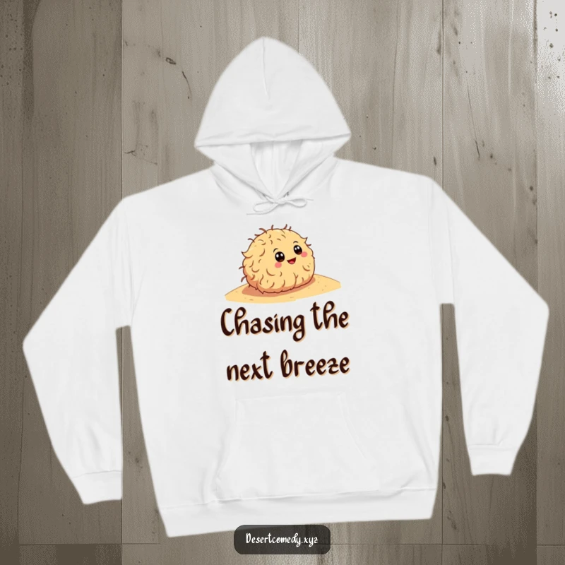 Funny hoodie featuring a happy tumbleweed with cartoon eyes, rolling down a sandy dune, embodying a free-spirited, adventurous mood.